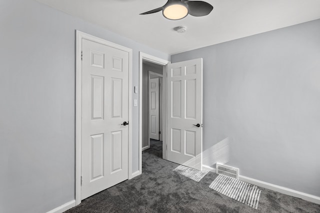 unfurnished bedroom with dark colored carpet and ceiling fan