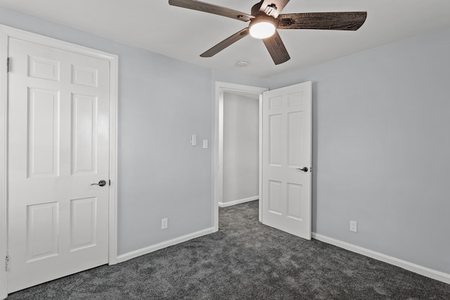 unfurnished bedroom with ceiling fan and dark carpet