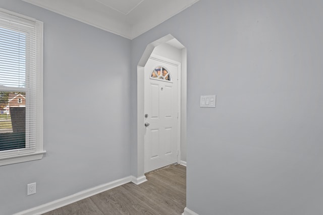 entryway featuring light wood-type flooring and crown molding