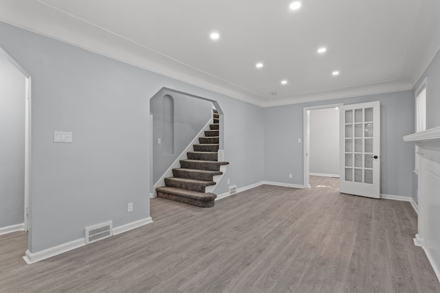 unfurnished living room with french doors and light wood-type flooring