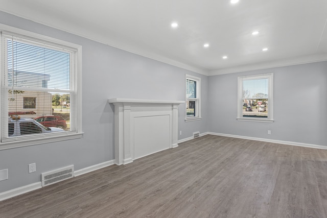 unfurnished living room featuring hardwood / wood-style flooring and crown molding