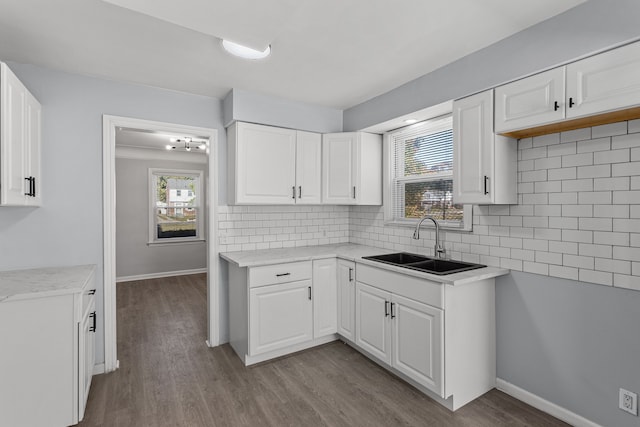 kitchen featuring white cabinets, decorative backsplash, light hardwood / wood-style floors, and sink