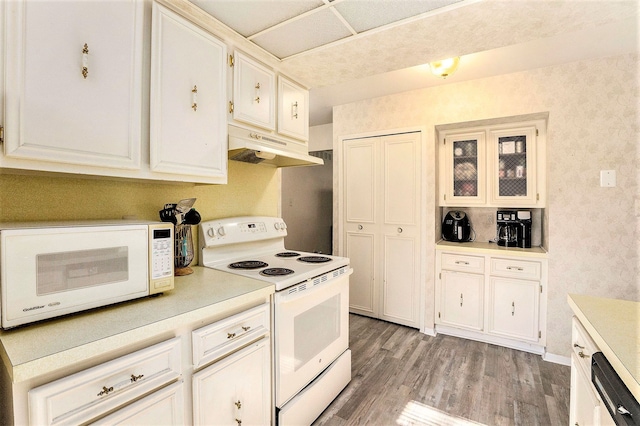 kitchen with white cabinets, white appliances, and hardwood / wood-style flooring