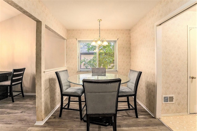 dining area with an inviting chandelier and hardwood / wood-style flooring