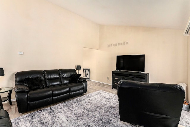 living room featuring lofted ceiling and hardwood / wood-style flooring