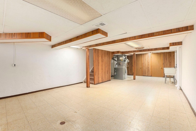 basement with heating unit and a drop ceiling