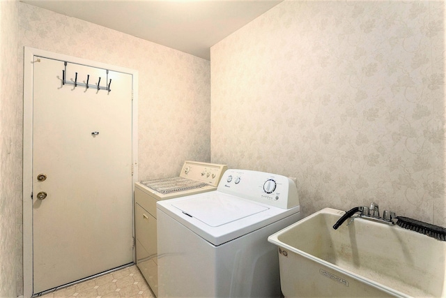 laundry area with separate washer and dryer and sink