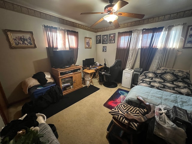 carpeted bedroom featuring multiple windows and ceiling fan