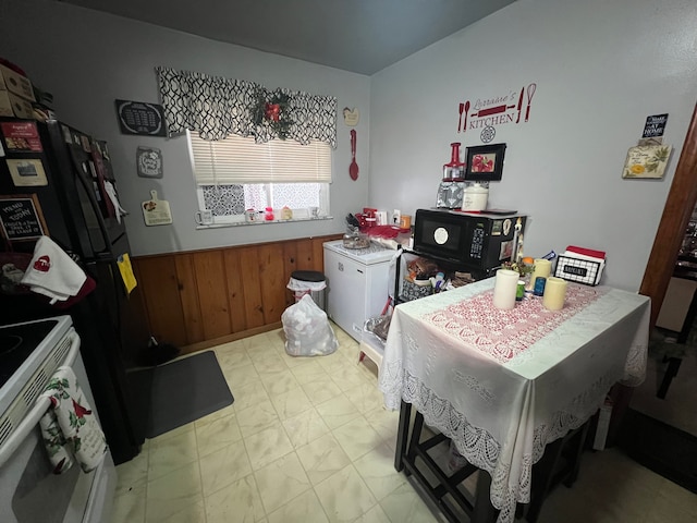 kitchen featuring electric range and wooden walls