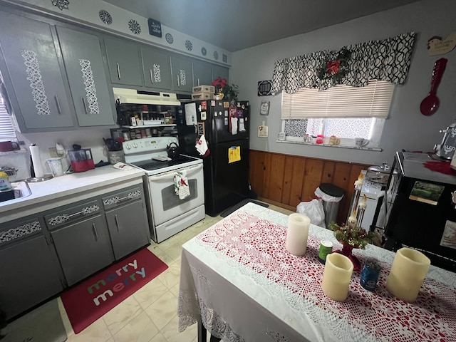 kitchen with wooden walls, sink, and black appliances