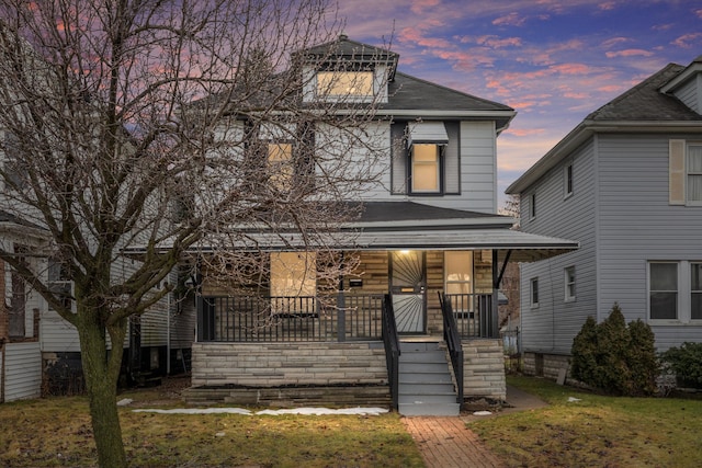 front facade featuring a yard and covered porch