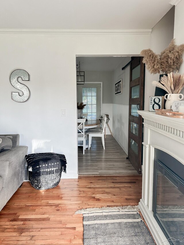 living room featuring wood-type flooring and crown molding