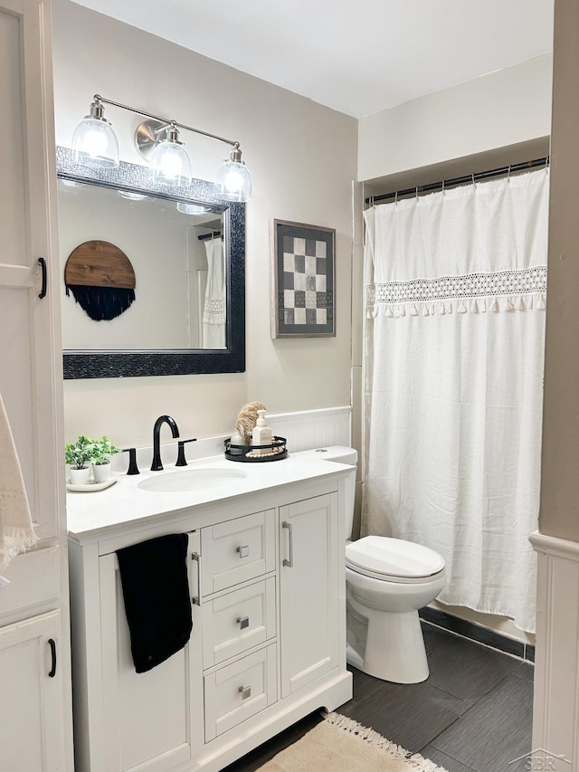 bathroom featuring vanity, curtained shower, and toilet