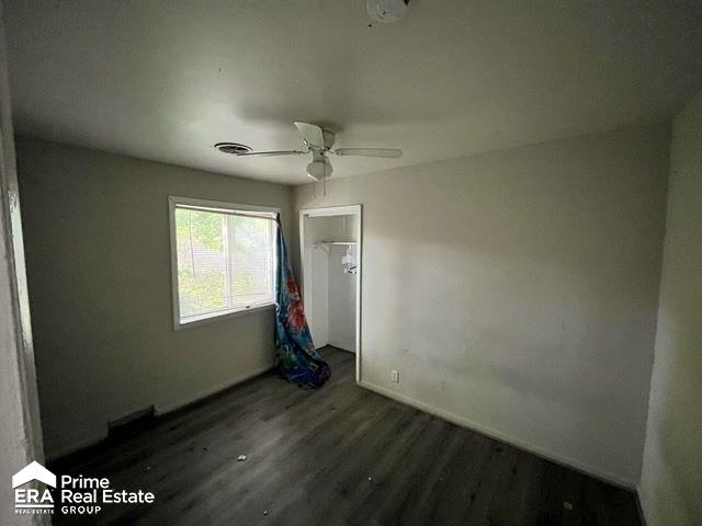 unfurnished bedroom featuring dark hardwood / wood-style floors and ceiling fan