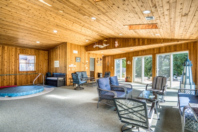 carpeted living room with wood walls, wood ceiling, and lofted ceiling with skylight