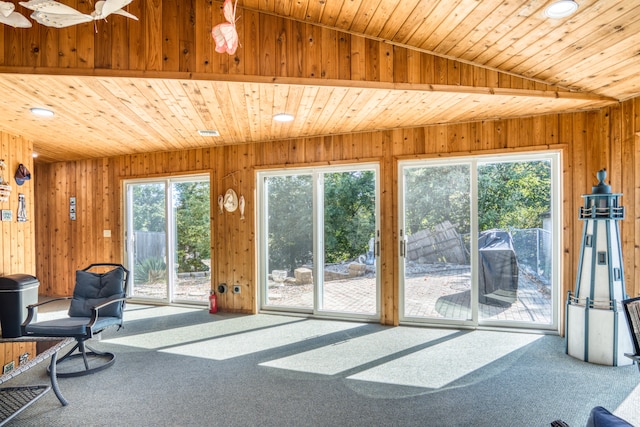 interior space with wooden walls, carpet floors, wood ceiling, and vaulted ceiling