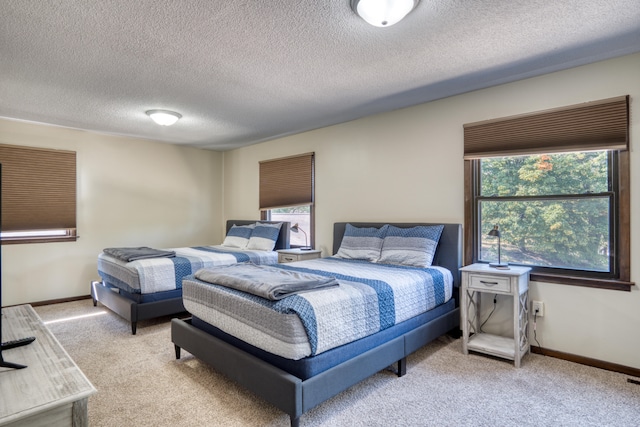 carpeted bedroom featuring a textured ceiling and multiple windows