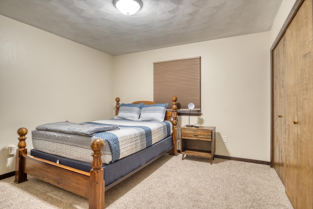 bedroom featuring light carpet, a textured ceiling, and a closet