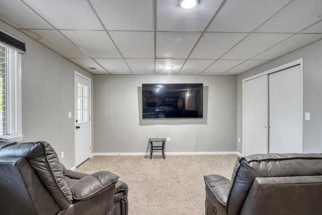 carpeted living room featuring a drop ceiling and a wealth of natural light