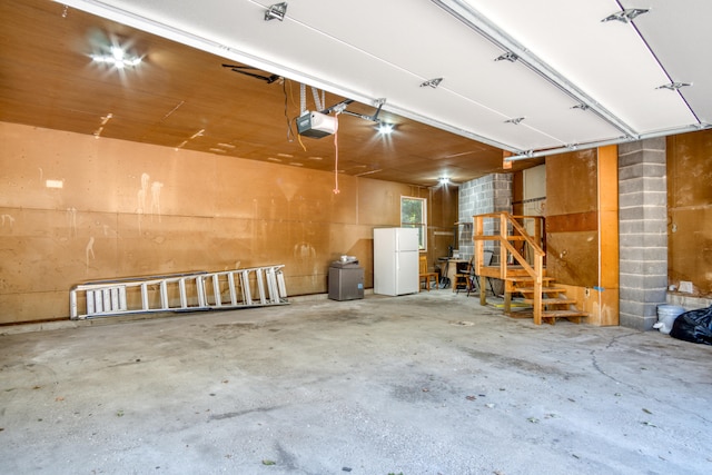 garage with a garage door opener and white refrigerator