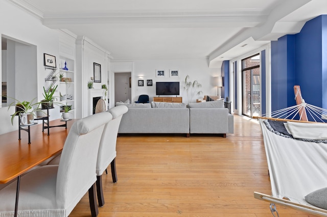 living room with beam ceiling, crown molding, and light hardwood / wood-style flooring