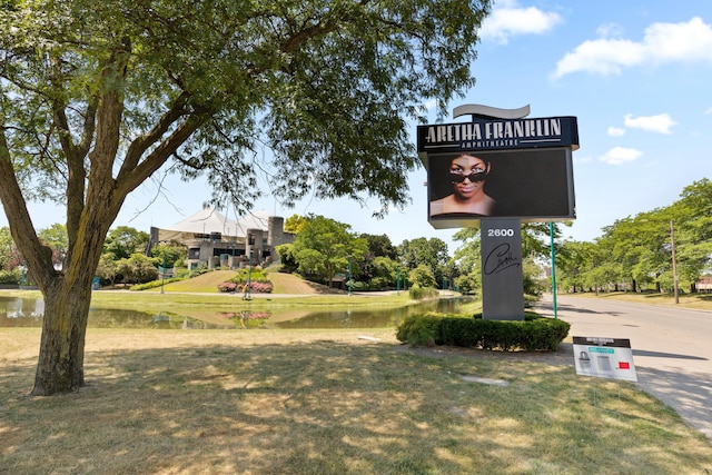 view of property's community featuring a lawn and a water view