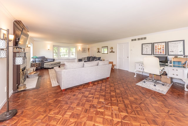 living area with visible vents, crown molding, and baseboards