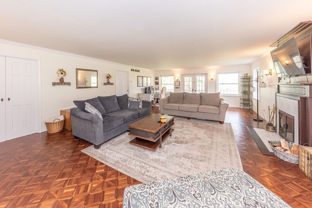 living area with ornamental molding, a fireplace with flush hearth, and visible vents