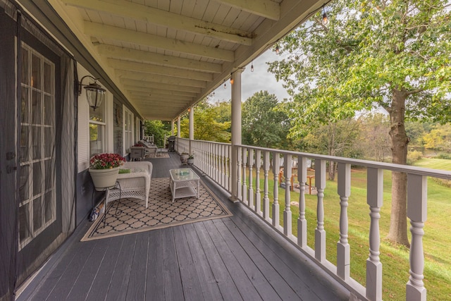 wooden terrace featuring a lawn