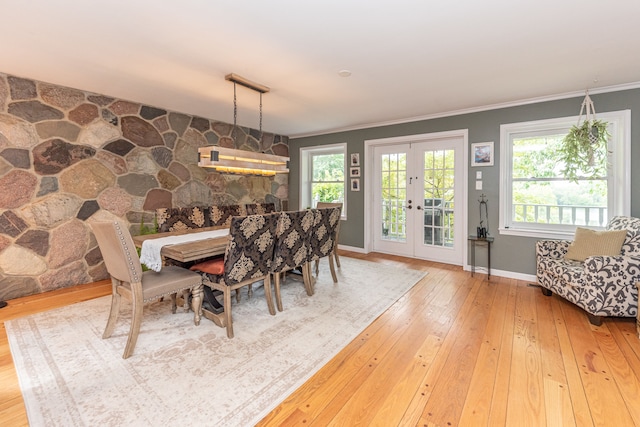 dining room featuring french doors, ornamental molding, plenty of natural light, and hardwood / wood-style flooring