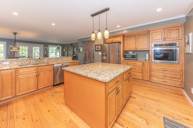 kitchen with stainless steel appliances, a sink, light wood-style flooring, and ornamental molding