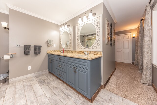 bathroom featuring double vanity, baseboards, walk in shower, crown molding, and a sink