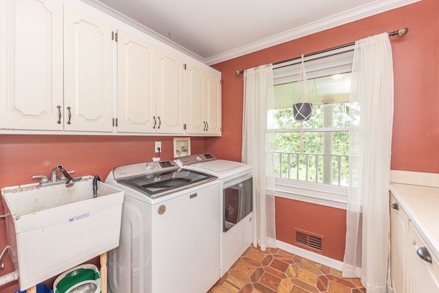 clothes washing area featuring cabinet space, visible vents, ornamental molding, a sink, and washer and dryer