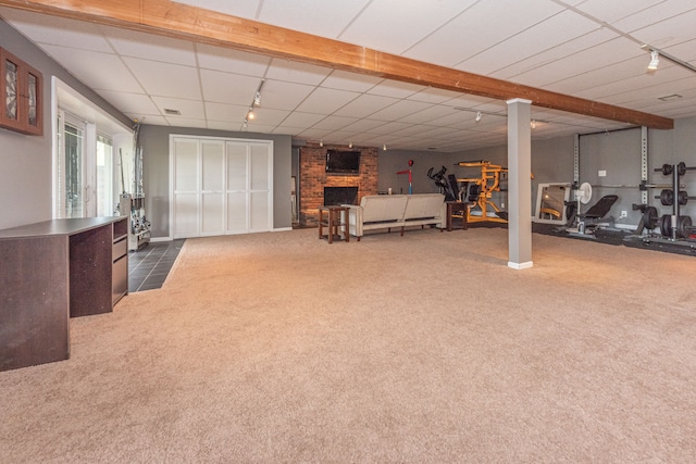 below grade area featuring carpet floors, rail lighting, and a fireplace