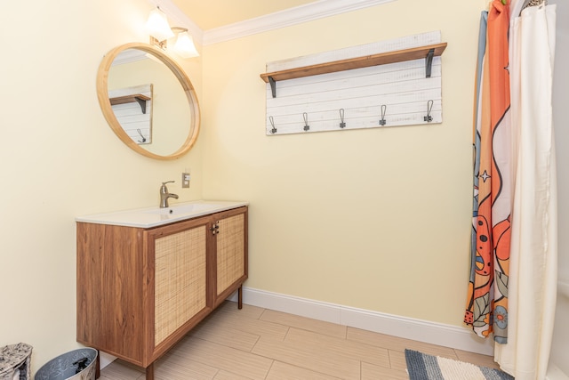 bathroom featuring a shower with curtain, ornamental molding, vanity, and baseboards