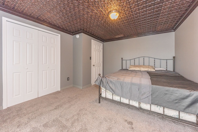 carpeted bedroom with ornamental molding, a closet, and an ornate ceiling