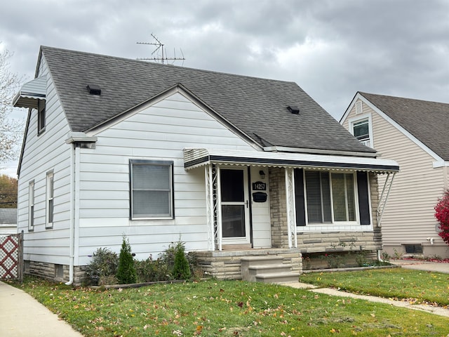 bungalow featuring a front lawn