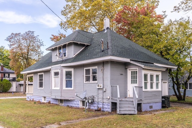 rear view of property featuring a lawn