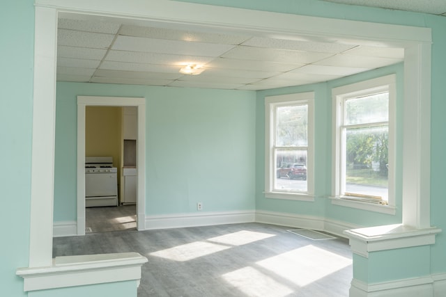 unfurnished room with wood-type flooring and a drop ceiling