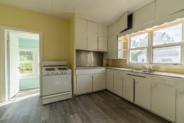 kitchen featuring white cabinetry, a wealth of natural light, white gas stove, and sink