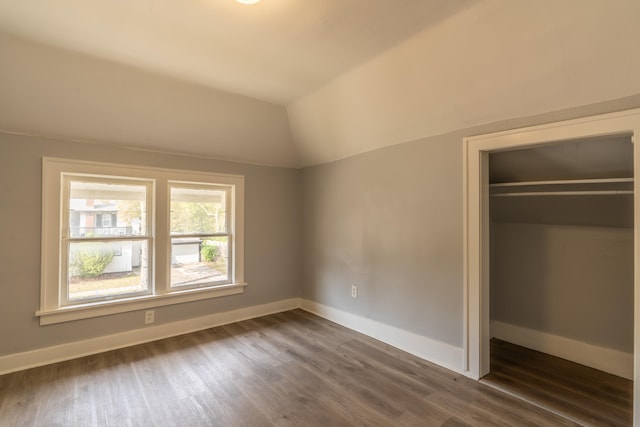 unfurnished bedroom featuring a closet, dark hardwood / wood-style flooring, and vaulted ceiling