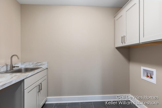 laundry room featuring baseboards, a sink, cabinet space, and hookup for a washing machine