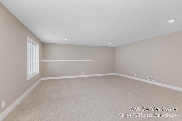 empty room with light colored carpet, visible vents, baseboards, and recessed lighting