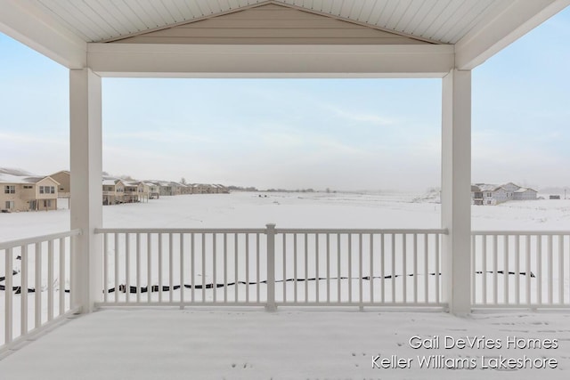 snow covered deck featuring a residential view