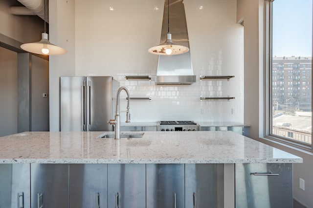 kitchen featuring stainless steel appliances, light stone counters, hanging light fixtures, and sink