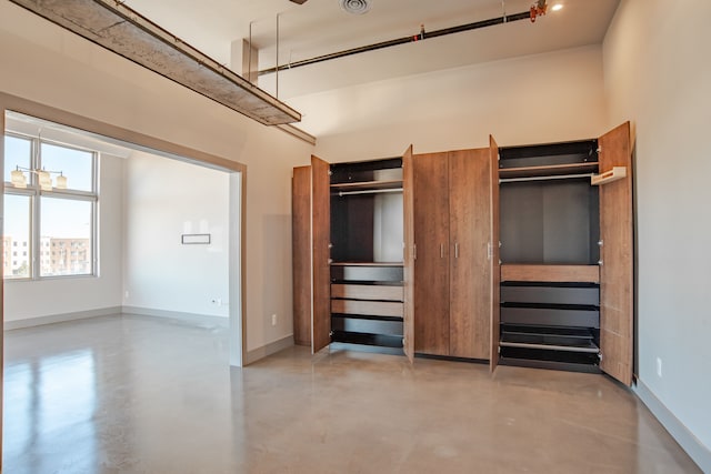 2987 Franklin St Unit 3Ab, Detroit, MI 48207 - unfurnished bedroom featuring finished concrete floors, baseboards, and multiple closets