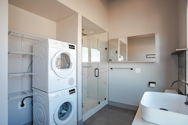 laundry room featuring stacked washer / drying machine and sink