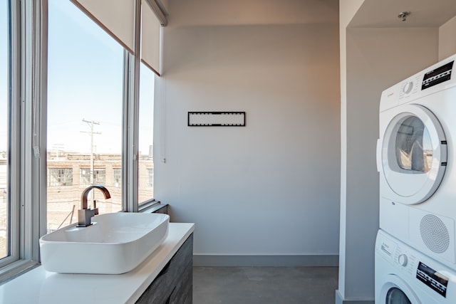 laundry area featuring stacked washer and clothes dryer and sink