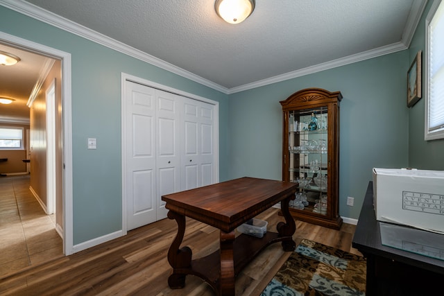 office featuring a textured ceiling, crown molding, and dark wood-type flooring