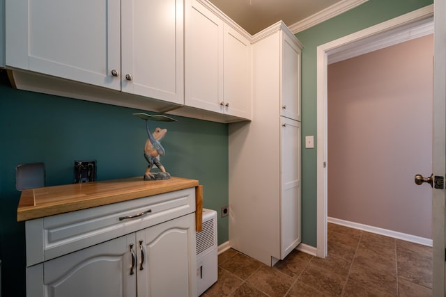 clothes washing area featuring cabinets, electric dryer hookup, and crown molding